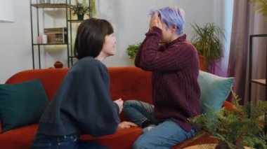 Two lesbian women family couple. Homosexual female girl gay making a surprise engagement ring love proposal of marriage to her beloved woman. Accepting emotionally say yes. LGBT people at home room
