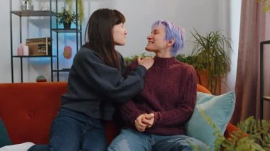 Happy two lesbian women family couple or girls friends smiling friendly, glad expression looking away, relaxation feel satisfied, good news, positive pregnancy test at home. LGBT people IVF maternity