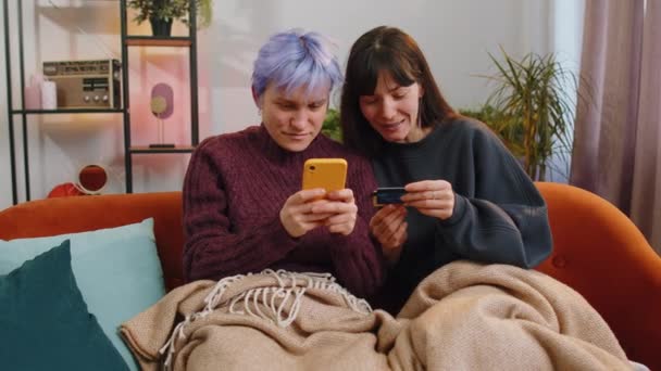 Två Lesbiska Gifta Kvinnor Par Använder Kreditkort Och Smartphone Samtidigt — Stockvideo