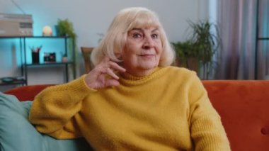 Mutlu, sakin, son sınıf öğrencisi bir bayan, dostça gülümsüyor, mutlu bir yüz ifadesi başka tarafa bakıyor, dinleniyor, rahatlıyor konseptten tatmin oluyor iyi haberler, zaferi kutluyor. Yaşlı büyükanne oturma odasında.