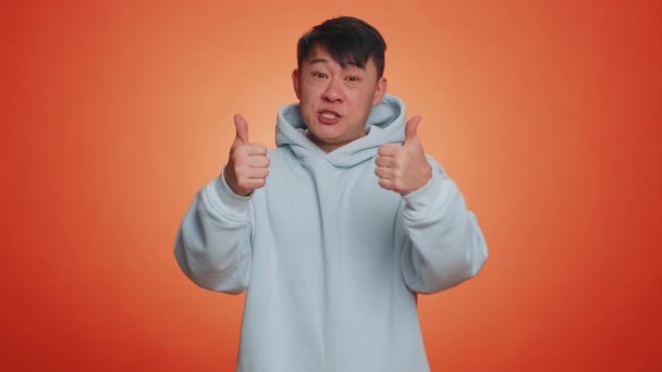 아시아의 잘생긴 사업가가 엄지손가락을 고개를 끄덕이며 성공적으로 즐기고 오렌지 스튜디오 — 비디오
