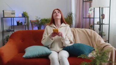 Repair work at neighbours. Irritated woman girl relaxing on couch cover ears with pillows annoyed by noisy neighbors suffer from headache wish silence. Thin walls at home flat without sound insulation