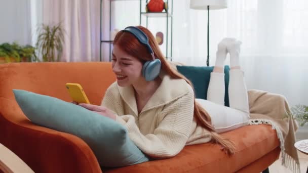 Fericită Femeie Roșcată Bucuros Căști Fără Fir Relaxare Culcat Canapea — Videoclip de stoc