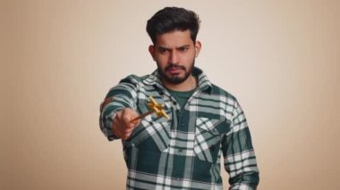 Magician wizard man gesturing with magic wand fairy stick, making wish come true, casting magician spell, advertising holidays sale discount. Handsome indian guy isolated on beige studio background