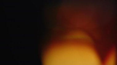 Işık sızıntısı 4K görüntüsü. Lens parlaklığı bokeh örtüleri, yanan alev arka planı. Görüntülerinizi birleştirmek, videoyu biçimlendirmek, dönüşümleri sağlamak için. Odaklanmış lamba flaş ışını etkisi. Işık titreşimleri ve ışıltı