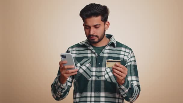 Cliente Índio Sincero Usando Cartão Crédito Smartphone Durante Transferência Dinheiro — Vídeo de Stock