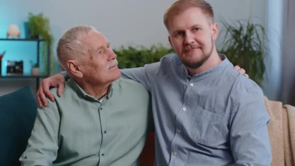 할아버지와 손자가 행복하게 껴안고 아버지와 거실의 소파에 연대감 — 비디오