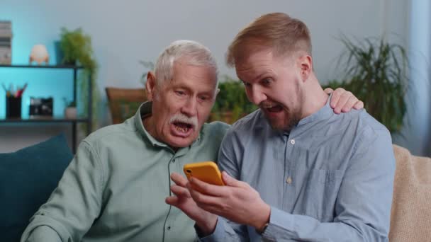 Avô Sênior Aprende Como Usar Smartphone Neto Adulto Jovem Pai — Vídeo de Stock