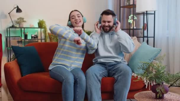 Szczęśliwa Rozradowana Młoda Rodzina Poślubiła Parę Mężczyzn Bezprzewodowych Słuchawkach Tańczących — Wideo stockowe