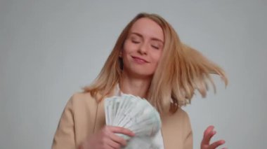 Resmi takım elbiseli zengin patron kadın hayran, başarılı iş kariyeri, piyango talihlisi, büyük gelir ve servet gibi banknotlar sallıyor. Gri arka planda izole edilmiş iş kızı