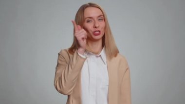 Seni seçiyorum. Resmi kıyafetli kadın kamerayı işaret ediyor ve neşeli bir ifadeyle bakıyor, seçim yapıyor, yön gösteriyor. İş gülümseyen kız, gri stüdyo arka planında tek başına.