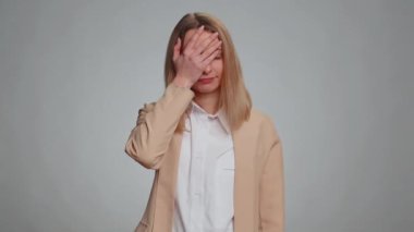 Avuç içi. Yazıklar olsun sana. Üzgün iş kadını surat hareketi yapıyor, sıkılıyor, hayal kırıklığına uğruyor, kötü haber. Resmi takım elbiseli bir kadın. Gri stüdyo arka planında izole edilmiş güzel bir kadın