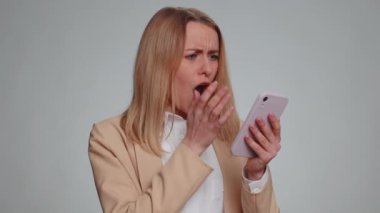 Hüzünlü iş kadını cep telefonu daktilosu kullanıyor. Ani piyango sonuçlarını kaybediyor. Kötü talih, kayıp, başarısızlık. Mutsuz kız, gri stüdyo duvarında tek başına, kapalı alanda.