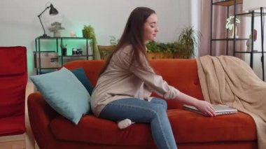 Serbest çalışan kadın dizüstü bilgisayarı açıyor, not defteriyle eğitime başlıyor, mesajlar gönderiyor, online alışverişler yapıyor, evdeki oturma odasında film izliyor. Kanepede oturan kızın portresi. Yaşam biçimi