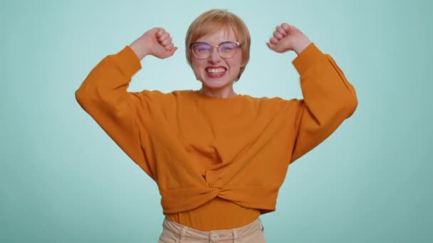 快乐快乐的女人喊着 举起拳头作为手势我做到了 庆祝成功 彩票中奖 好消息 蓝色工作室墙壁背景上的金发女孩 — 图库视频影像