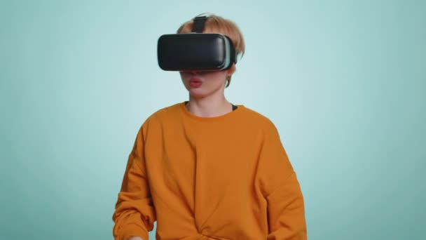 仮想現実未来技術を使用して女性Vrアプリのヘッドセットヘルメットは 映画の映画を見て シミュレーション3D 360ビデオゲームをプレイする ブロンドの短い髪の女の子は青のスタジオの背景に隔離され — ストック動画