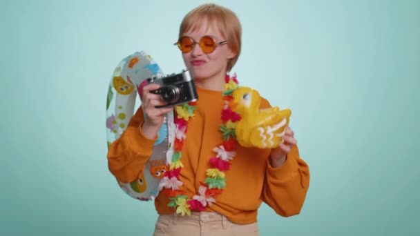 レトロカメラで写真を撮るサングラスの幸せな女性観光客の写真家 夏休み休暇 海辺への旅行 かなり短い髪ブロンド女の子旅行者上の青背景 — ストック動画