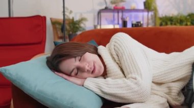 Yorgun genç bir kadın yatağında uzanıyor ve evinde dinleniyor. Kaygısız güzel kız uyukluyor, rahat turuncu koltukta yastıklarla uyuyakalıyor. Gözlerini kapadı, tek başına gündüz uykusunun tadını çıkardı.