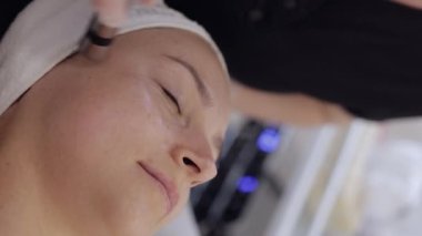 Enjeksiyonsuz mezoterapi ya da elektroporasyon. Güzellik doktoru, kadın müşteriyi güzellik kliniğinde terapiye götürür. Kız cilt bakımı anti-yaş spa prosedürü. Estetik kozmetoloji. Dikey video