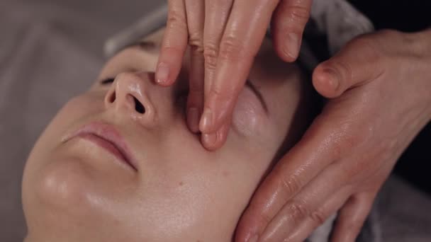 Doświadczony Lekarz Terapeuta Robi Kobiecie Relaksujący Masaż Twarzy Spa Dłońmi — Wideo stockowe