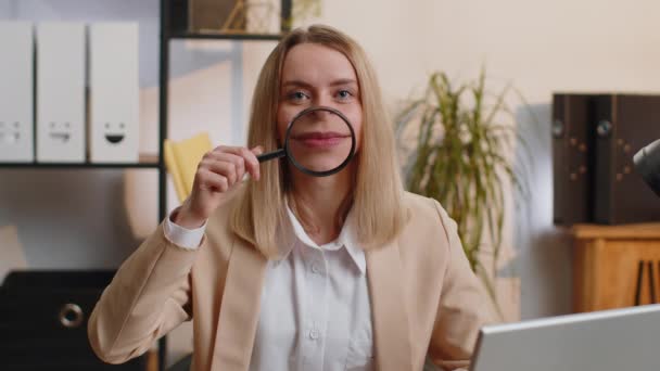 女商人把放大镜戴在牙齿上 满面春风地看着相机 在现代的家庭办公室办公桌前 脸上挂着滑稽的笑脸 兴奋的女经理自由职业者 — 图库视频影像