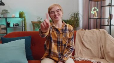 Mutsuz genç bir kadın nahoş berbat bir fikre tepki veriyor, kötü kaliteden memnun değil, el sallıyor, başını sallıyor hayır, reddet fikri, evlenme teklifini sevme. Oturma odasındaki kanepede oturan kız.