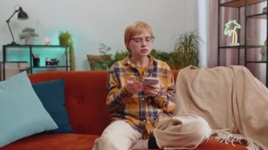 Repair work at neighbours. Irritated woman girl relaxing on couch cover ears with pillows annoyed by noisy neighbors suffer from headache wish silence. Thin walls at home flat without sound insulation