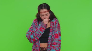 Sağlıksız genç bir kadın öksürürken elleriyle ağzını kapatıyor, kendini hasta hissediyor, alerji ya da viral enfeksiyon belirtileri, ateş ağrısı virüsü. Güzel hippi kız tek başına krom anahtar arka planda, yeşil ekranda