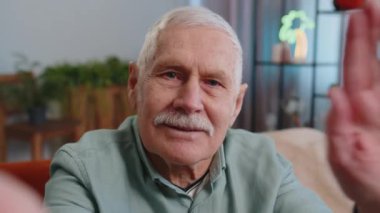 Büyükbabamın internetten selfie çekerken, ailesiyle kamera önünde sohbet ederken, evde el sallayarak selamlaşırken görüntüsü. İletişim, toplantı. Olgun adam akıllı telefon konuşması yapıyor.