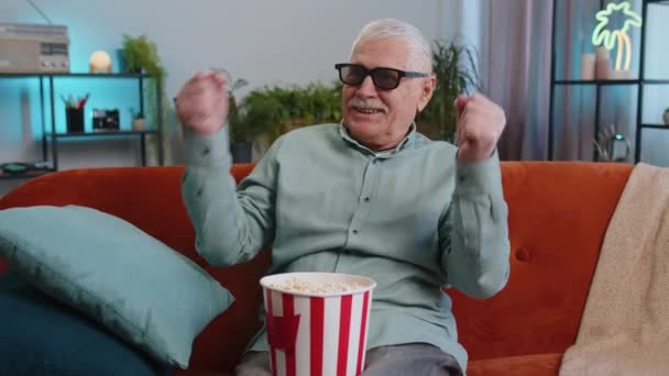 Ανώτερος Παππούς Άνθρωπος Γυαλιά Στον Καναπέ Τρώει Σνακ Ποπ Κορν — Αρχείο Βίντεο