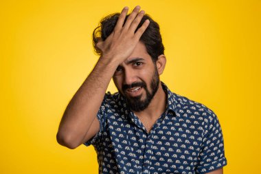 Sakallı Hintli bir adam umutsuzluk yalnızlık, sinir krizi, mağlubiyet piyango sonuçları, kötü şans kaybı, şanssız haberler karşısında şaşırıyor. Hindu genç adam stüdyo sarı arka planda izole