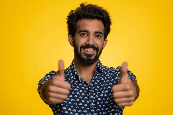 穿着衬衫的印度年轻人竖起大拇指表示同意某事 给出了肯定的答复 推荐做广告喜欢好的 一个人孤零零地躺在黄色的工作室里 留着胡子 — 图库照片