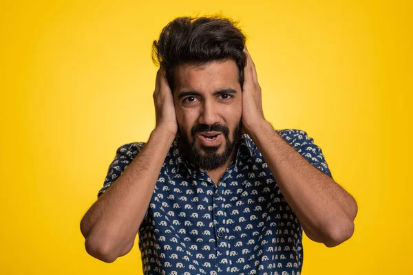 Dont want to hear and listen. Frustrated annoyed irritated indian man covering ears gesturing No, avoiding advice ignoring unpleasant noise loud voices. Handsome hindu guy alone on yellow background