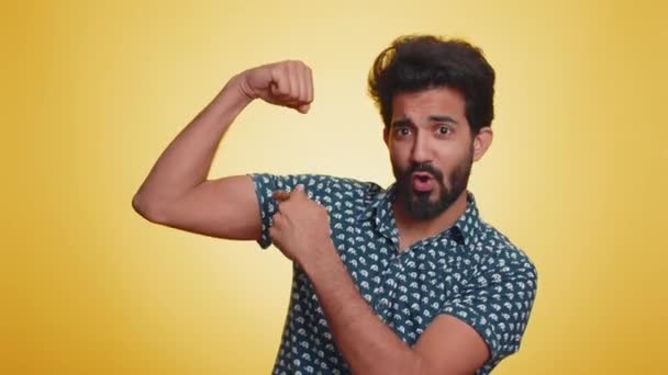 我很坚强体格健美的印度男人表现出二头肌和自信 感受到为争取权利而奋斗的力量 获得成功的能量 在工作室黄色背景上被隔离的印度教男子 — 图库视频影像