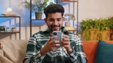 Mutlu Hintli adam cep telefonu daktilo kullanarak 