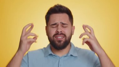 Sakallı beyaz adamın parmakları çapraz, umutsuzluk, yalnızlık, sinir krizi, mağlubiyet piyango sonuçları, kötü talih, kayıp, şanssız haberler. Sarı arka plandaki adam