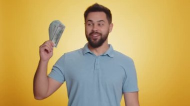 Zengin patron, hayran, başarılı iş kariyeri, piyango kazananı, büyük gelir ve servet gibi banknotlar sallıyor. Sarı arka planda izole edilmiş yakışıklı beyaz adam.