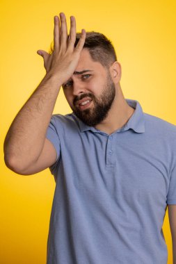 Avuç içi. Yazıklar olsun sana. Kafası karışmış genç bir adamın avuç içi hareketi. Sıkılmış, kararsız, hayal kırıklığına uğramış, kötü haber. Yakışıklı, sarı stüdyo arka planında tek başına izole edilmiş.