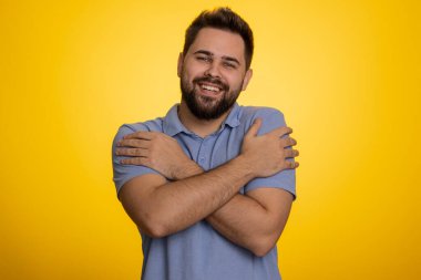 Gel bana, sana sarılmak istiyorum. Beyaz tenli yakışıklı adam ellerini uzattı ve sana sarıldı. Hoş bir ifade, aşk duyguları. Genç adam sarı stüdyo geçmişinde tek başına izole edilmiş. İnsan yaşam tarzları