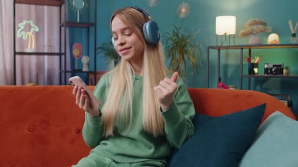 기사보기 헤드폰을 아파트 소파에 활기넘치는 디스코 음악을 행복해 사람들의 — 비디오