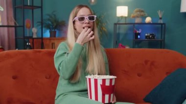 Üç boyutlu gözlüklü heyecanlı bir kadın kanepeye oturup patlamış mısır yiyor ve ilginç bir TV oyunu izliyor, sosyal medya içerikli çevrimiçi bir film çekiyor. Kız eğleniyor