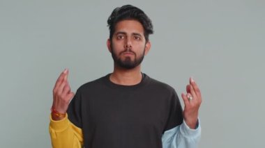 Mutlu Hintli adam bağırıyor, başarıyı kutluyor, kazanıyor, doğum gününü kutluyor, piyango hedefini tutturuyor, iyi haber, zafer. Genç Hintli adam gri stüdyo arka planında izole edilmiş.