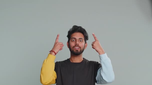 幸せなインド人男性を親指を表示し 頭の上に空の場所を指す 商業テキストの碑文 商品の宣伝バナーのためのコピースペースの広告エリア 灰色の背景に隔離されたヒンズー教の男 — ストック動画