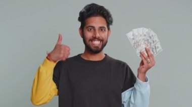 Zengin patron Hindu 'nun elinde bir hayran, başarılı bir iş kariyeri, piyango talihlisi, büyük gelir ve servet gibi banknotlar sallaması. Gri arka planda kapalı alanda izole edilmiş yakışıklı Hintli adam.