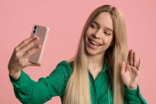 快乐的高加索女性旅行博客 在智能手机上自拍 与家人或朋友在网上进行视频通话 现场翻译流 粉红背景的漂亮女孩 在室内 — 图库照片