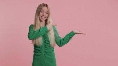 Beyaz kadın başparmaklarını gösterip boş yeri işaret ediyor. Ticari metinler için reklam alanı, afiş, logo, ürün tanıtımı için fotokopi alanı. Genç kız pembe stüdyo geçmişinde izole edilmiş.