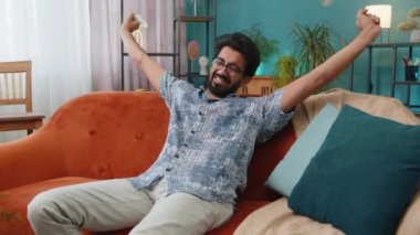 Yorgun Hintli adam rahat kanepeye uzanıp dinleniyor, gündüz uyukluyor. Kafasının arkasında el ele tutuşan kaygısız Hintli adamın portresi. Evde kanepede uyuyakalıyor.