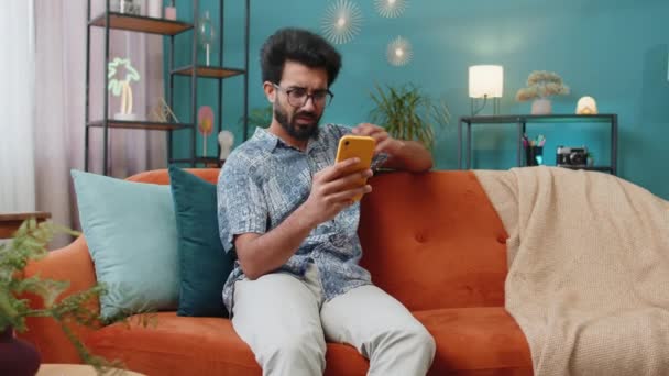Sad Displeased Indian Man Use Smartphone Typing Browsing Loses Becoming — 비디오