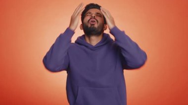 Sakallı Hintli bir adam umutsuzluk yalnızlık, sinir krizi, mağlubiyet piyango sonuçları, kötü şans kaybı, şanssız haberler karşısında şaşırıyor. Hindu genç adam stüdyo turuncu arka planda izole