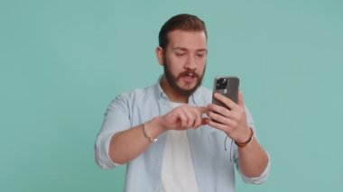 Mutlu, heyecanlı Lübnanlı adam tişörtlü, akıllı telefon daktilo kullanıyor ve bağırarak evet diyor. Harika bir galibiyet, iyi haber, piyango hedefi başarıyı kutluyor, oyunu kazanıyor.